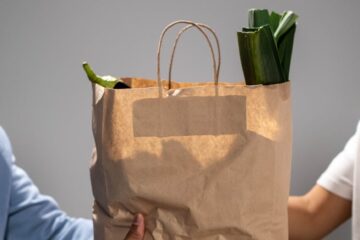 distributing a bag of food aid to a beneficiary